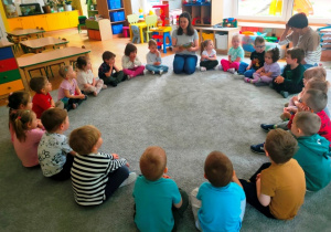 Dzieci w skupieniu słuchają bajkę.