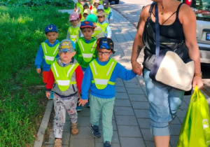 Dzieci idą parami do autokaru.