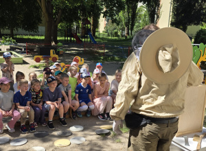 Dzieci uczestniczą w spotkaniu z pszczelarzem.