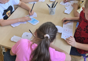 Dzieci pracują przy stoliku - projektują swoje budowle.