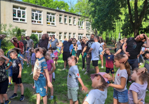 Rodzice i dzieci rozgrzewają się przed sportowymi zmaganiami.