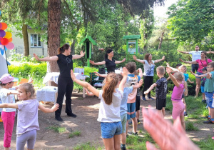 Rodzice i dzieci rozgrzewają się przed sportowymi zmaganiami.