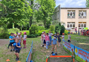 Dzieci wykonują sportowe zadania przygotowane przez Drużynę Kangura.