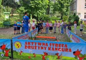 Zmagania sportowe z Drużyną Kangura - Pan Janek wita się z dziećmi i zaprasza do zabawy.