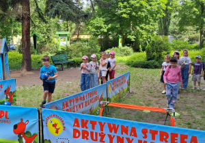 Kolejne dzieci wykonują sportowe zadania przygotowane przez Drużynę Kangura.