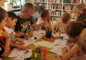 Dzieci kolorują obrazki o tematyce ekologicznej.