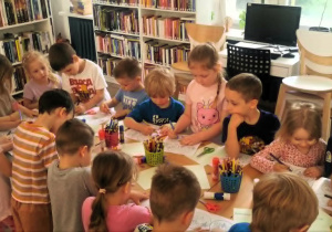 Dzieci kolorują obrazki o tematyce ekologicznej.