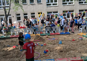Dzieci, rodzice, pracownicy oraz przyjaciele naszego przedszkola bawią się wspólnie na pikniku rodzinnym.