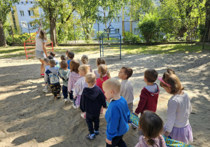 Dzieci zwiedzą kolejne zakamarki przedszkolnego ogrodu.