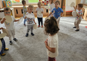 Dzieci bawią się wspólnie na dywanie do wesołej piosenki o kropce.