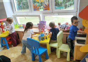Dzieci bawią się w kąciku kuchennym.