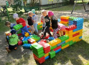 Dzieci budują bazę z mega klocków.