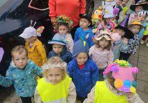 Dzieci spacerują po osiedlu w kolorowych nakryciach głowy.