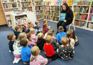 Pani bibliotekarka prezentuje dzieciom książkę- przedstawia im bajkowego bohatera.