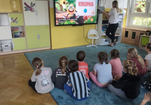 Dzieci oglądają bajkę edukacyjną o kropce.