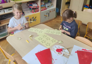 Dziewczynki wycinają gwiazdki do pracy.