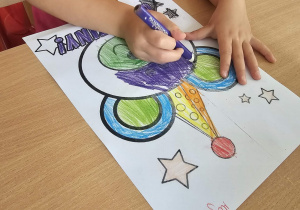 Dziecko tworzy laurkę dla kolegów.
