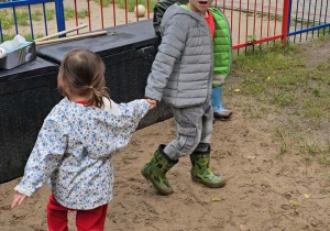 Chłopiec tańczy z młodszą koleżanką.