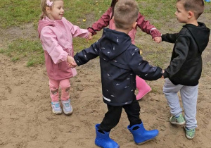 Dzieci tańczą w kole.