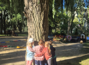 Dzieci tulą się do drzewa.