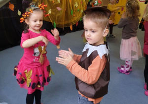 Dzieci tańczą w parach do jesiennych utworów.