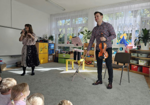 Prowadzący Audycję z Nutką rozmawiają z dziećmi o instrumentach.