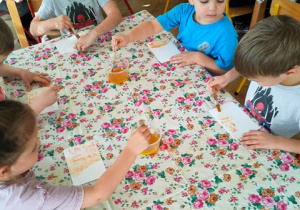 Dzieci odszukują na kartce napis zapisany magicznym atramentem.