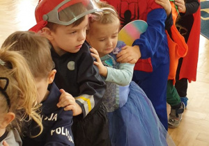 Dzieci ustawione jedno za drugim bawią się w zabawę taneczną "Jedzie pociąg..".