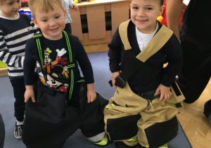 Alim i Julek ubrani w spodnie strażackie