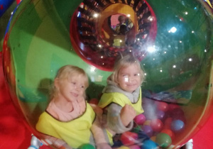 Hania i Kamilka siedzą w plastikowej kuli z piłkami