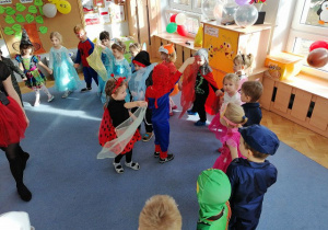 Dzieci tańczą w kole machając chusteczkami.