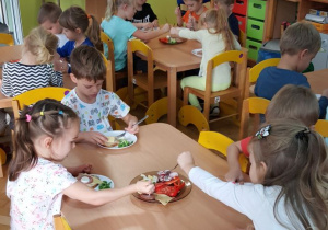 Dzieci samodzielnie komponują produkty żywnościowe na kanapkach.