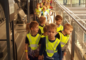 Dzieci idą jedno za drugim wąskim korytarzem w EC1.