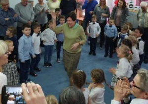 Nasze super Babcie wraz z dziećmi tańczą na dywanie.