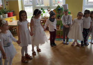 Dzieci tańczą we wspólnym dużym kole.