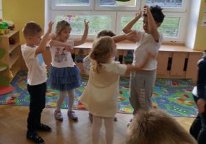 Dzieci tańczą w kilku osobowym kole.