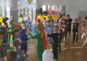 Przy wesołej muzyce dzieci tańczą w małych grupach.