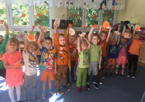 Dzieci pokazują wykonane przez siebie prace "pomarańcze".