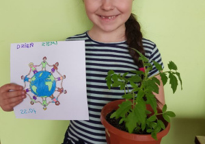 Lila prezentuje samodzielnie zasadzone pomidorki oraz rysunek w ramach obchodów Dnia Ziemi.