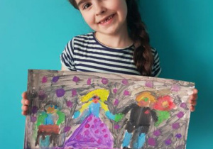 Dziewczynka prezentuje swoją prace plastyczną pt. "Malujemy muzykę".