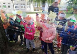 Dzieci malują na folii malarskiej w ogrodzie przedszkolnym.