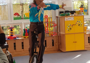 Cyrkowiec prezentuje jazdę na bicyclu.