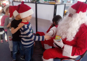 Dzieci witają się ze Świętym Mikołajem.