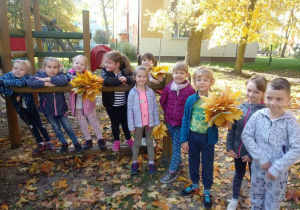 Dzieci pozują z liśćmi.