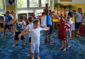 Dzieci stojąc w parach plecami są złączone ze sobą, naśladują ruchu wagi szalkowej