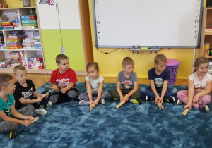 Grupa dzieci trzymająca patyki szykuje się do wystukiwania rytmu piosenki.