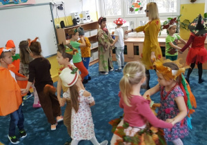 Dzieci tańczą w dwuosobowych kółeczkach.