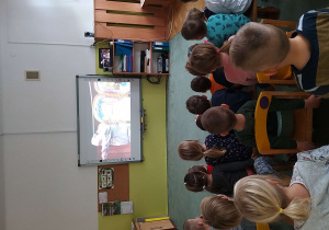 Dzieci ogladają na tablicy interaktywnej spektakl online pt. "Historia Daniela w Jaskini Lwa".