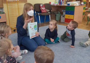 Dzieci słuchają w jaki sposób rozprzestrzenia się wirus.