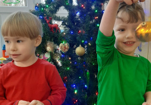 Dwóch chłopców pokazuje jakie bombki wybrali na choinkę.